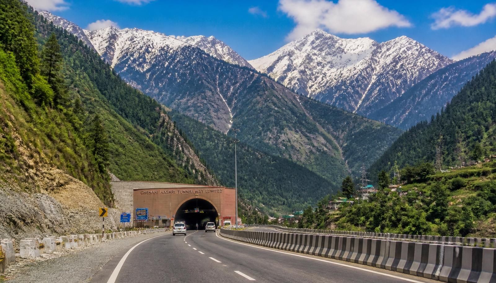 NH44 mountain highway leading into the Chenani-Nashri Tunnel with snow-capped Himalayan peaks, Jammu to Srinagar road trip